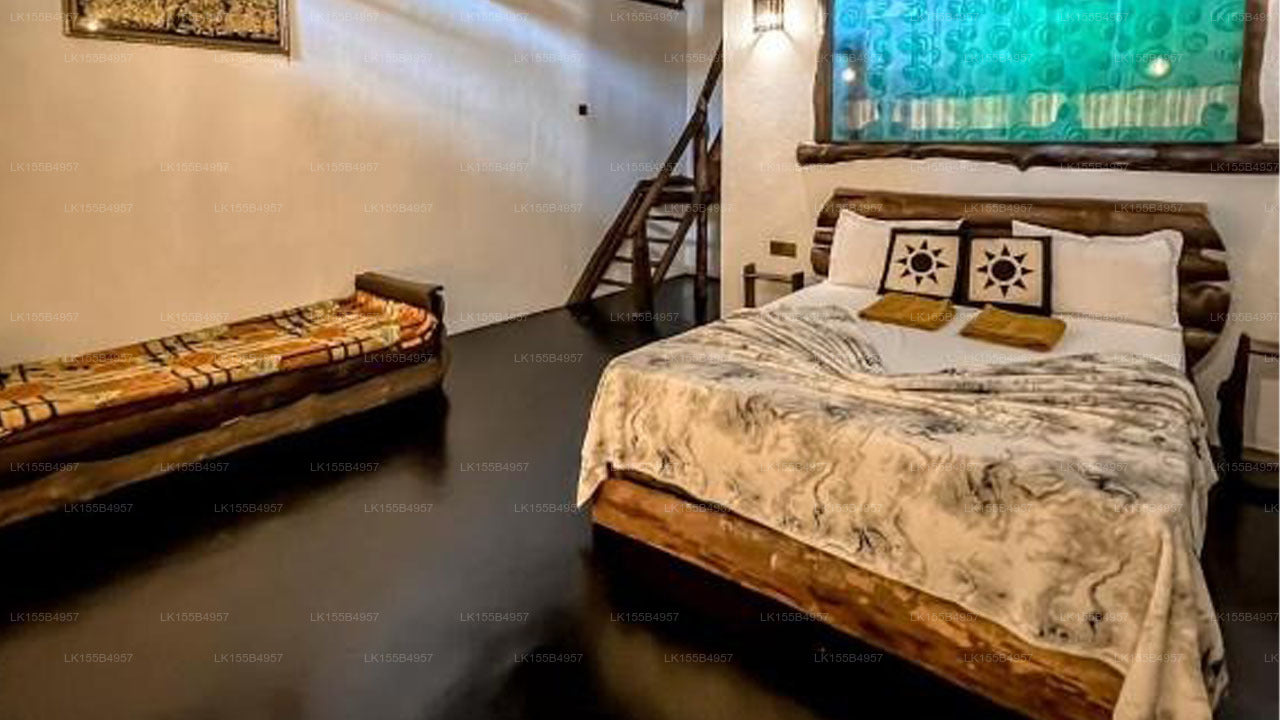 Bedroom with a bed and bench in a room with a staircase and wall art.