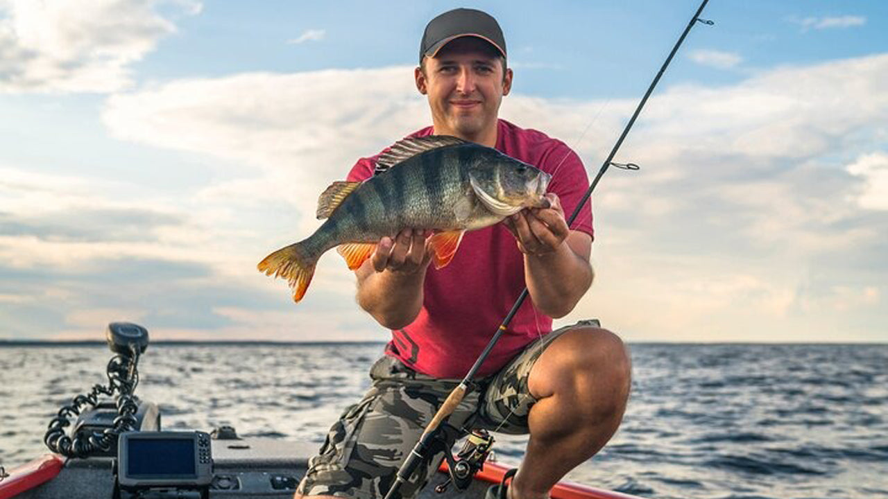 Man on a boat holding a fish he caught
