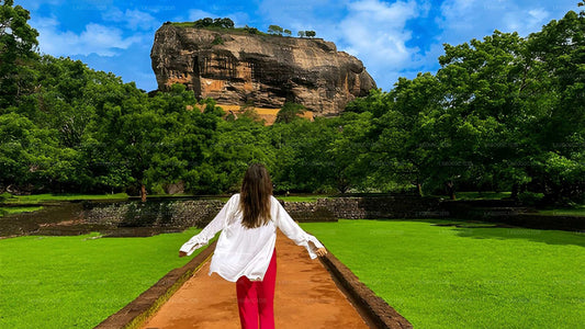 Woman standing on a path with Sigiriya Rock in the background