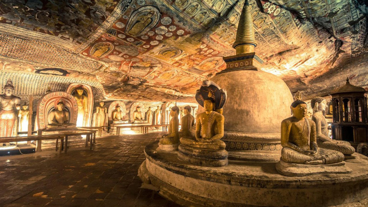Interior view of Dambulla Cave Temple with illuminated ceiling murals and Buddha statues
